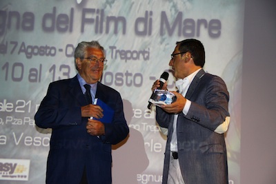 L’Assessore Ferro premia il prof. Stefanon con la statuetta in vetro di Marino Moscardino, la mascotte dell’Oasi Marina di Caorle.