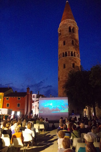 Il meraviglioso campanile cilindrico di Piazza Vescovado, a Caorle, sovrasta la platea piena del Festival